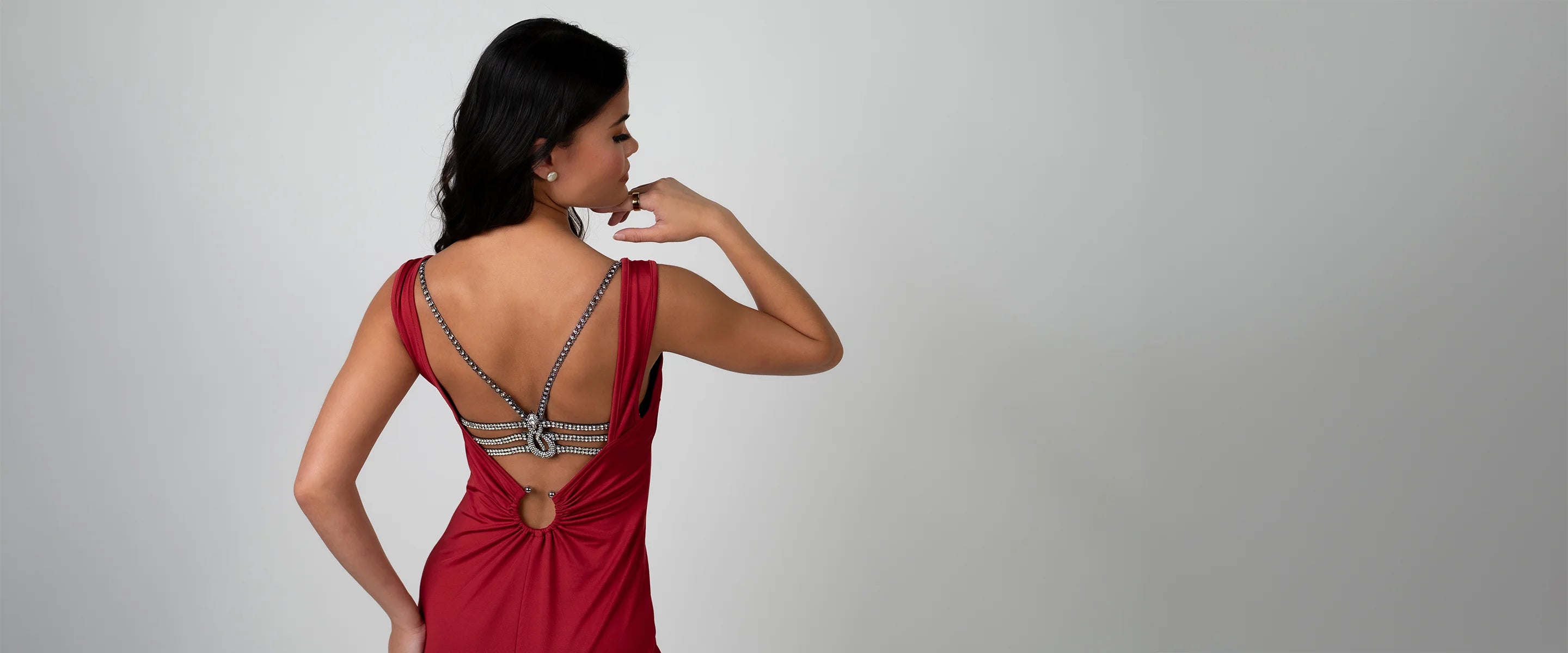 Woman wearing luxury lingerie bra on a backless dress on a gray background