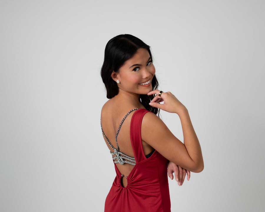 Woman looking over shoulder wearing luxury lingerie bra on a backless red dress